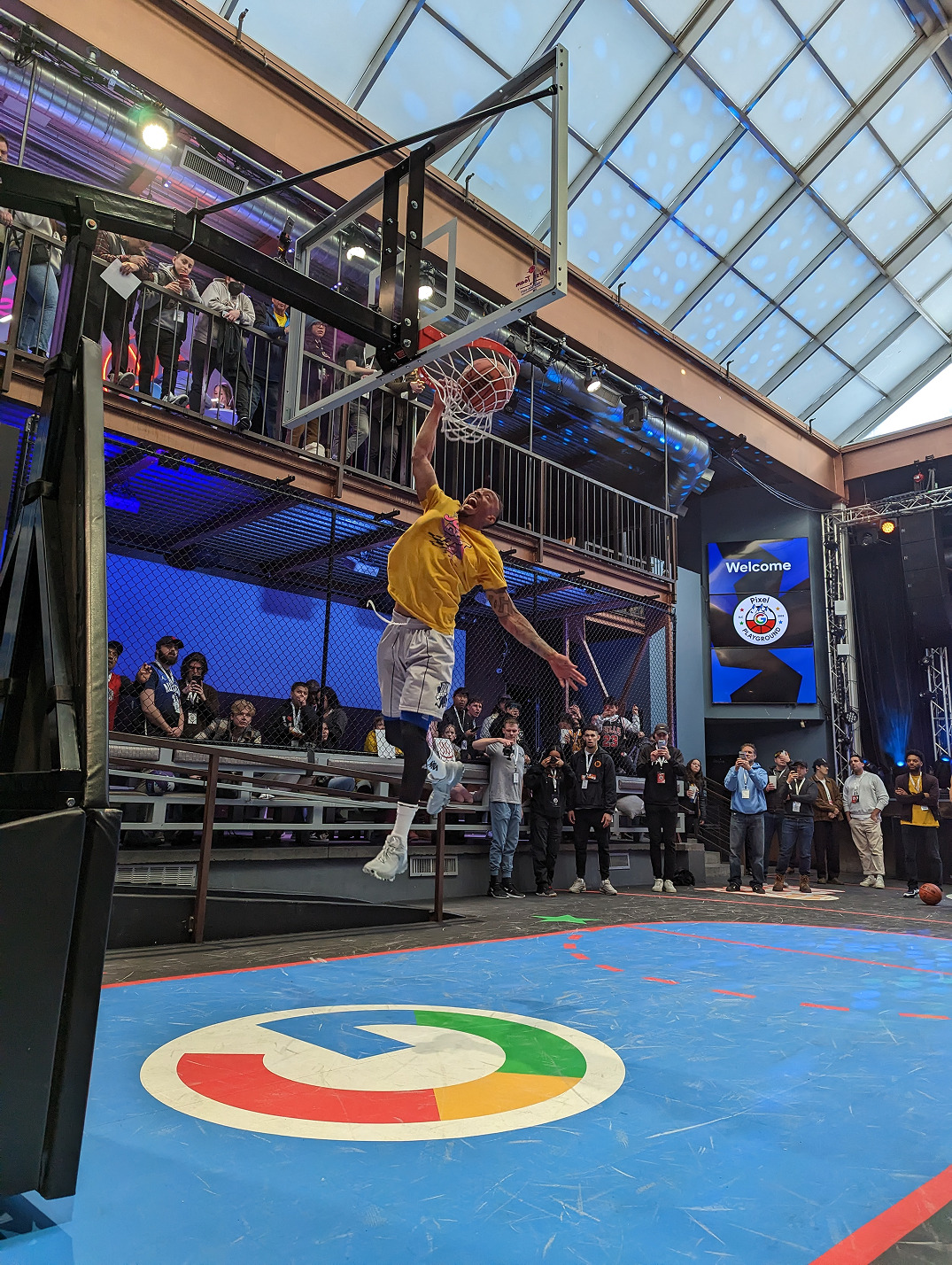 Athlete performing a dunk at the Google Pixel Baskeball Court.